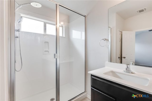 bathroom with vanity and a shower with door