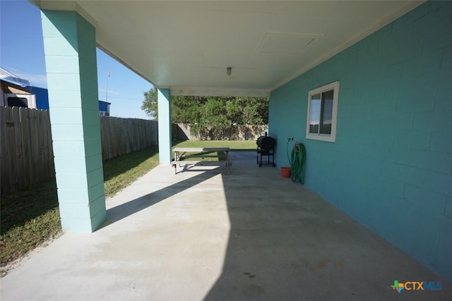 view of patio / terrace with a carport and a fenced backyard