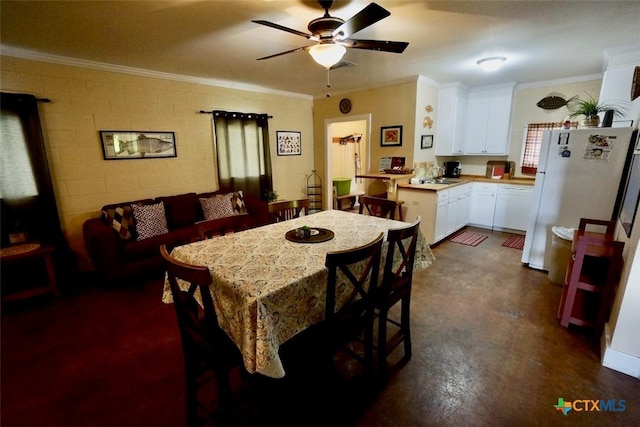 dining room featuring ceiling fan, concrete block wall, and ornamental molding