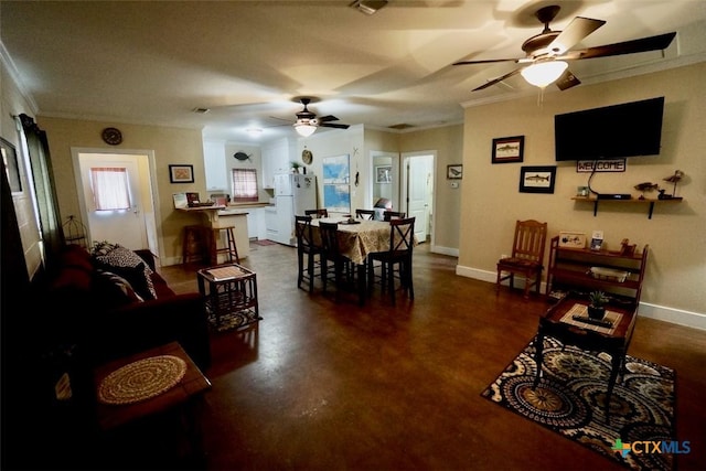 dining area with finished concrete floors, ornamental molding, baseboards, and ceiling fan