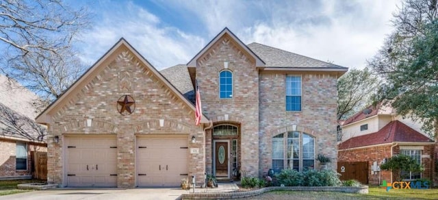 view of front of property with driveway, brick siding, an attached garage, and a shingled roof