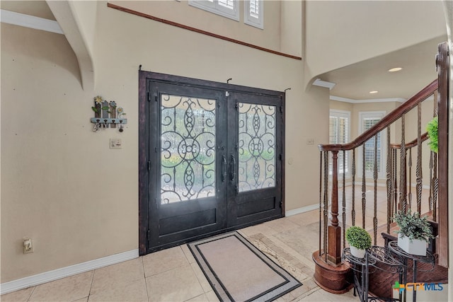 tiled foyer entrance featuring french doors and ornamental molding