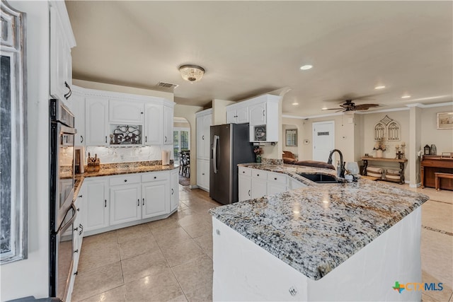 kitchen featuring white cabinetry, sink, stainless steel fridge with ice dispenser, and stone countertops