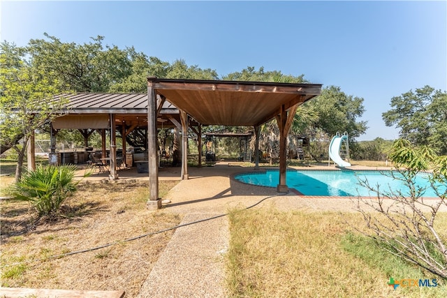 view of pool featuring a patio and a water slide