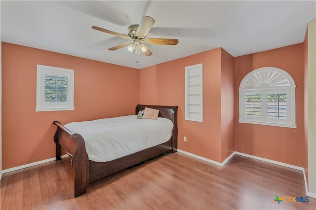 bedroom with ceiling fan and light wood-type flooring