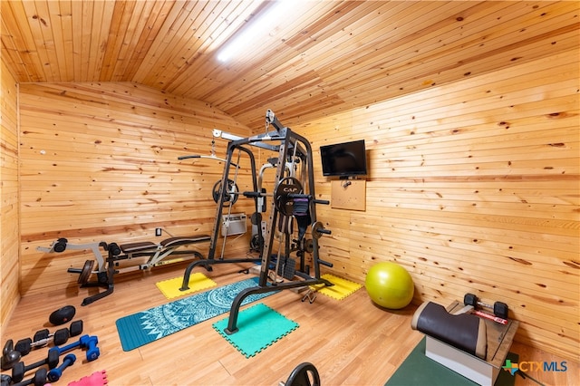 exercise area with wood walls, wood ceiling, light wood-type flooring, and lofted ceiling