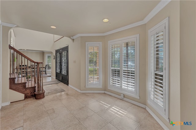 entrance foyer featuring light tile patterned floors, french doors, and ornamental molding