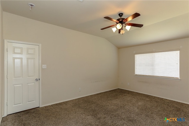 unfurnished room with lofted ceiling, ceiling fan, and dark carpet