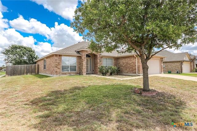 ranch-style house with a garage and a front lawn