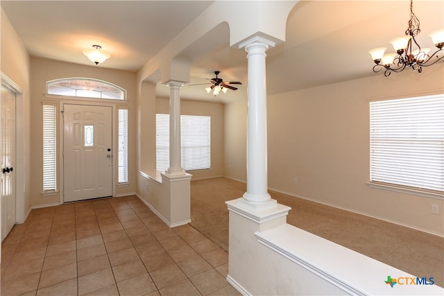 entryway with light colored carpet, ornate columns, and ceiling fan with notable chandelier