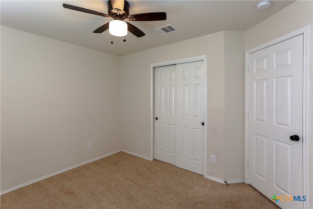 unfurnished bedroom with light colored carpet and ceiling fan