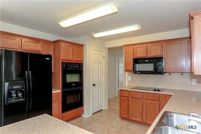 kitchen with decorative backsplash, black appliances, and sink