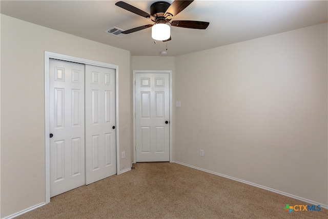 unfurnished bedroom featuring light carpet, ceiling fan, and a closet