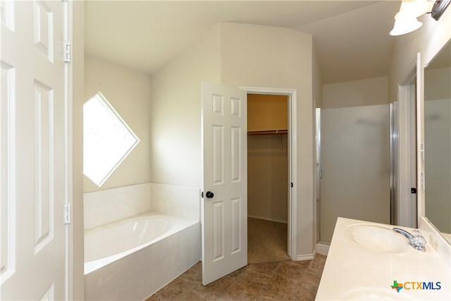 bathroom with shower with separate bathtub, tile patterned floors, vanity, and vaulted ceiling