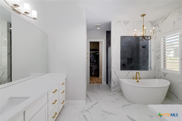 bathroom featuring plus walk in shower, vanity, an inviting chandelier, and tile walls