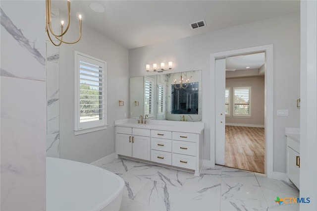 bathroom featuring a tub to relax in, vanity, a healthy amount of sunlight, and wood-type flooring