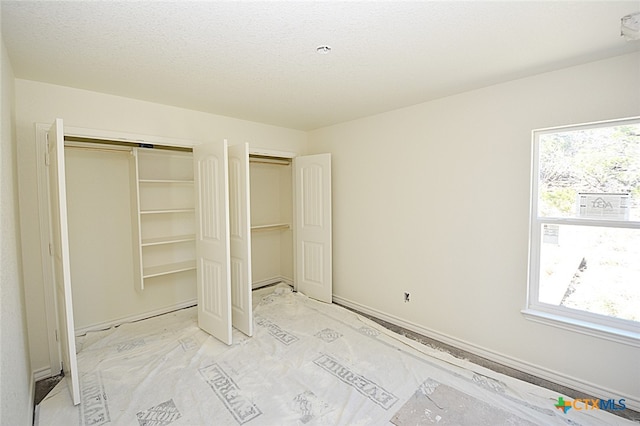 unfurnished bedroom featuring a textured ceiling and multiple windows