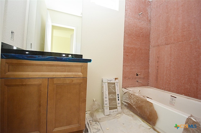 bathroom featuring vanity and a tub to relax in