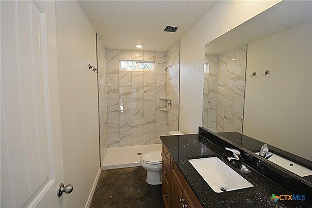 bathroom with a tile shower and a textured ceiling