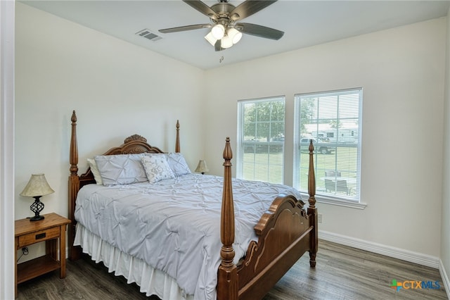 bedroom featuring multiple windows, ceiling fan, and dark hardwood / wood-style floors