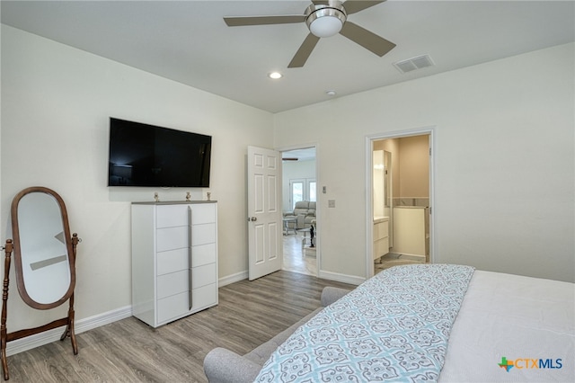 bedroom featuring light hardwood / wood-style floors, ceiling fan, and ensuite bathroom