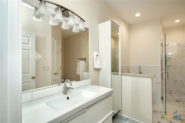 bathroom featuring vanity and a shower with door