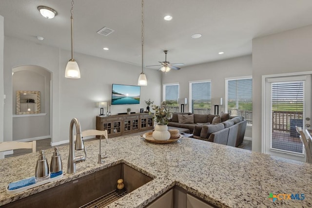 3214 Roan St, New Braunfels, TX 78130 - kitchen featuring a ceiling fan, light stone counters, open floor plan, decorative light fixtures, and recessed lighting