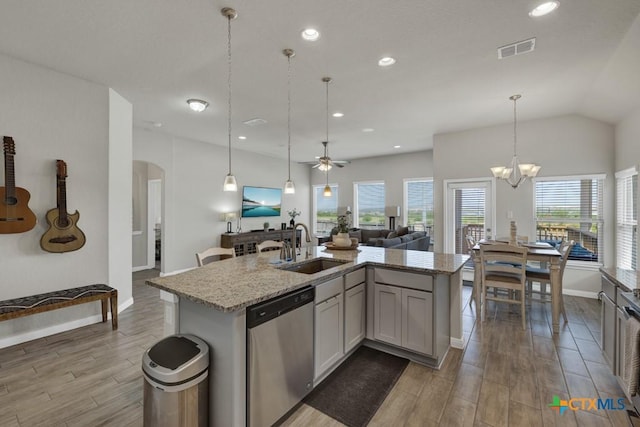 3214 Roan St, New Braunfels, TX 78130 - kitchen with stainless steel dishwasher, open floor plan, wood finished floors, arched walkways, and an island with sink