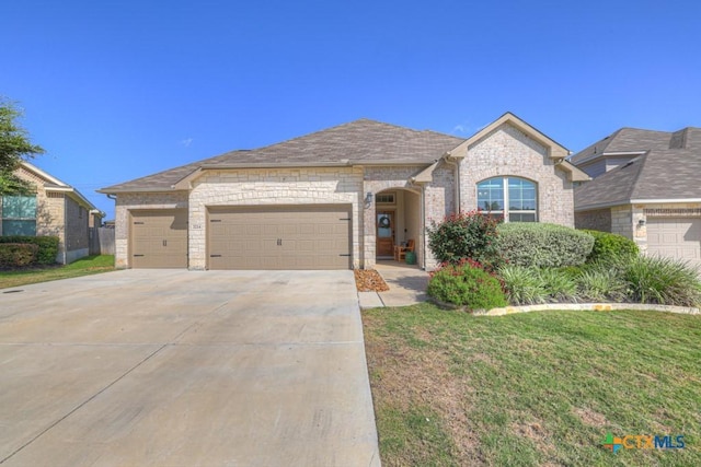 3214 Roan St, New Braunfels, TX 78130 - french country inspired facade with concrete driveway, an attached garage, brick siding, a front yard, and roof with shingles