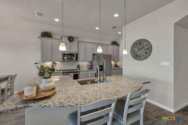 3214 Roan St, New Braunfels, TX 78130 - kitchen featuring stainless steel appliances, gray cabinets, dark wood-type flooring, a breakfast bar area, and recessed lighting