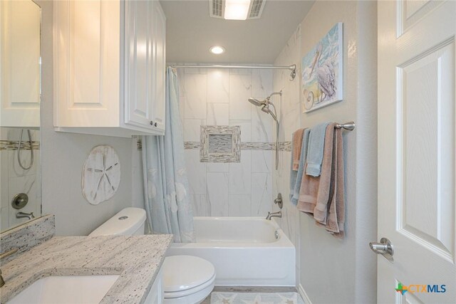 full bathroom featuring visible vents, vanity, toilet, and shower / tub combo with curtain