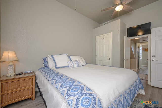 bedroom with vaulted ceiling, visible vents, ceiling fan, and wood finished floors