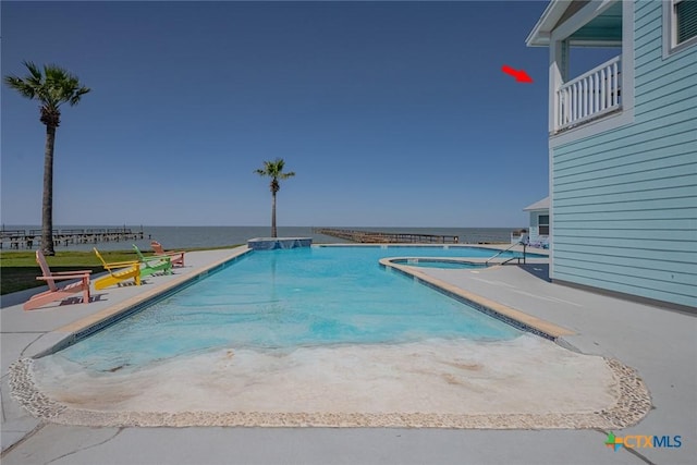 community pool with a patio, a community hot tub, and a water view