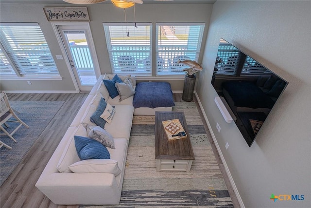 living area with baseboards and wood finished floors