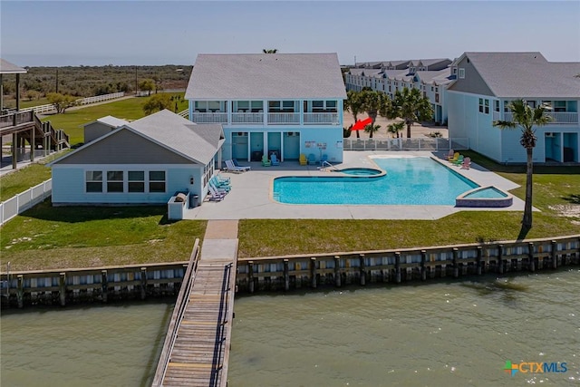 back of house with a yard, a water view, a balcony, and a patio area