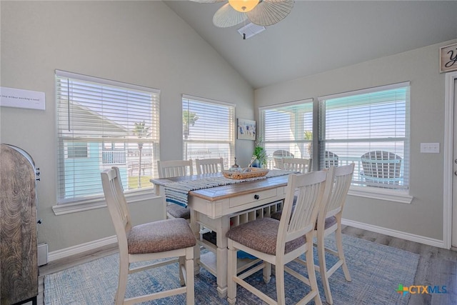 dining area with high vaulted ceiling, a ceiling fan, baseboards, and wood finished floors