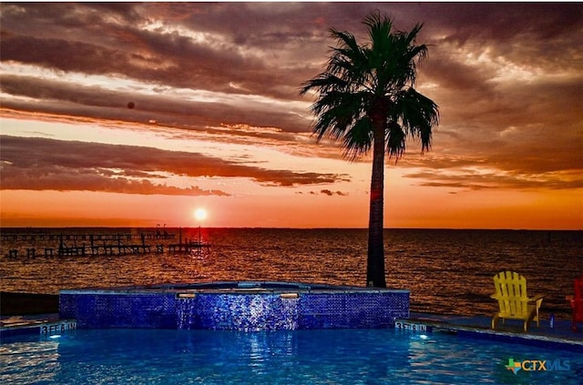 view of pool featuring a water view and a hot tub