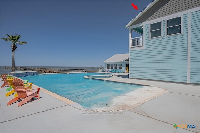 pool featuring a patio area and a water view