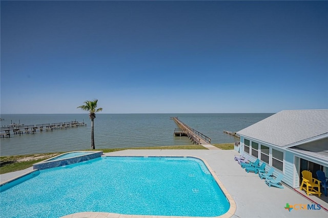 view of swimming pool featuring a patio area, a water view, and a pool with connected hot tub