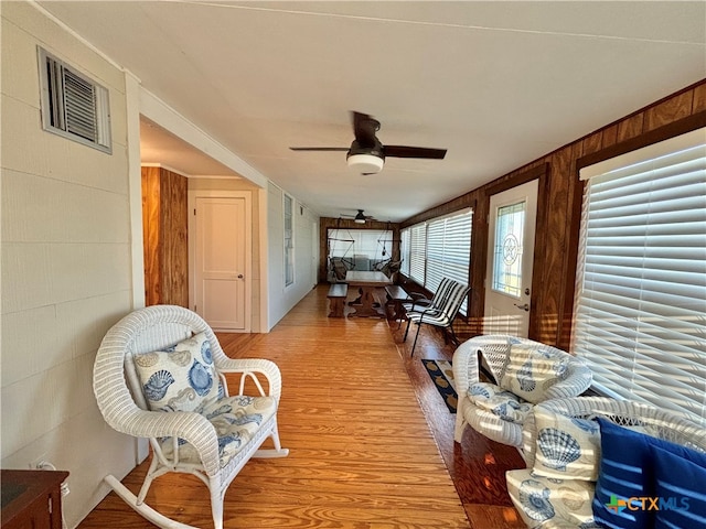 corridor featuring light hardwood / wood-style floors and wooden walls