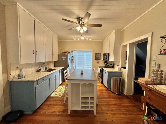 kitchen with stainless steel appliances, white cabinets, sink, and dark hardwood / wood-style flooring