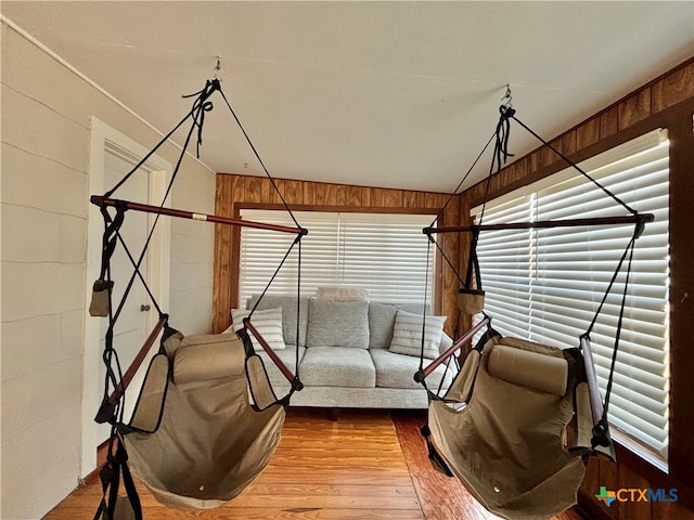 interior space with lofted ceiling, hardwood / wood-style flooring, and wooden walls