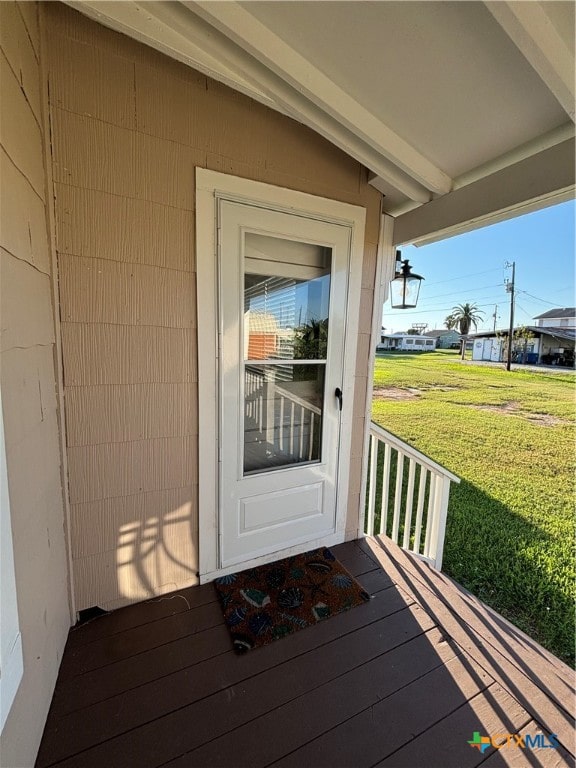 view of exterior entry with a lawn