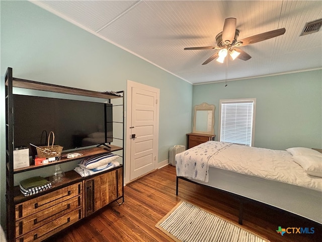 bedroom featuring dark wood-type flooring, ceiling fan, and ornamental molding