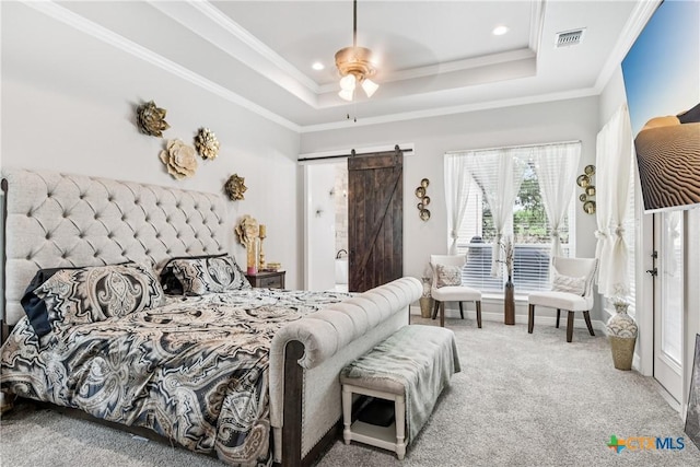bedroom with a barn door, carpet floors, a tray ceiling, ornamental molding, and recessed lighting