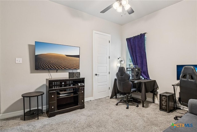 carpeted home office with a ceiling fan and baseboards