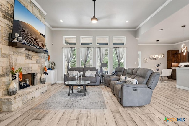 living area with light wood finished floors, a stone fireplace, crown molding, and recessed lighting
