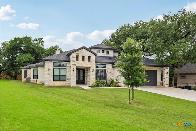 view of front of home with stone siding, concrete driveway, a front lawn, and a chimney