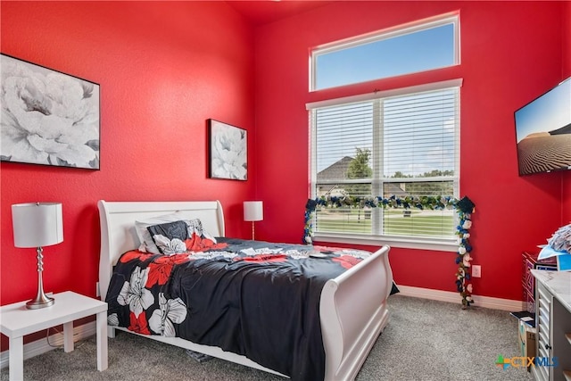 carpeted bedroom featuring baseboards and a towering ceiling