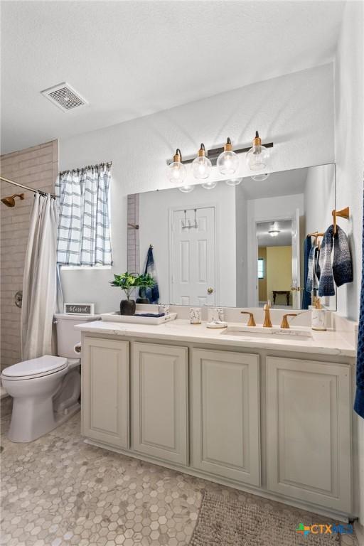 2604 Mikulec Dr, Killeen, TX 76542 - bathroom featuring a tile shower, vanity, and plenty of natural light